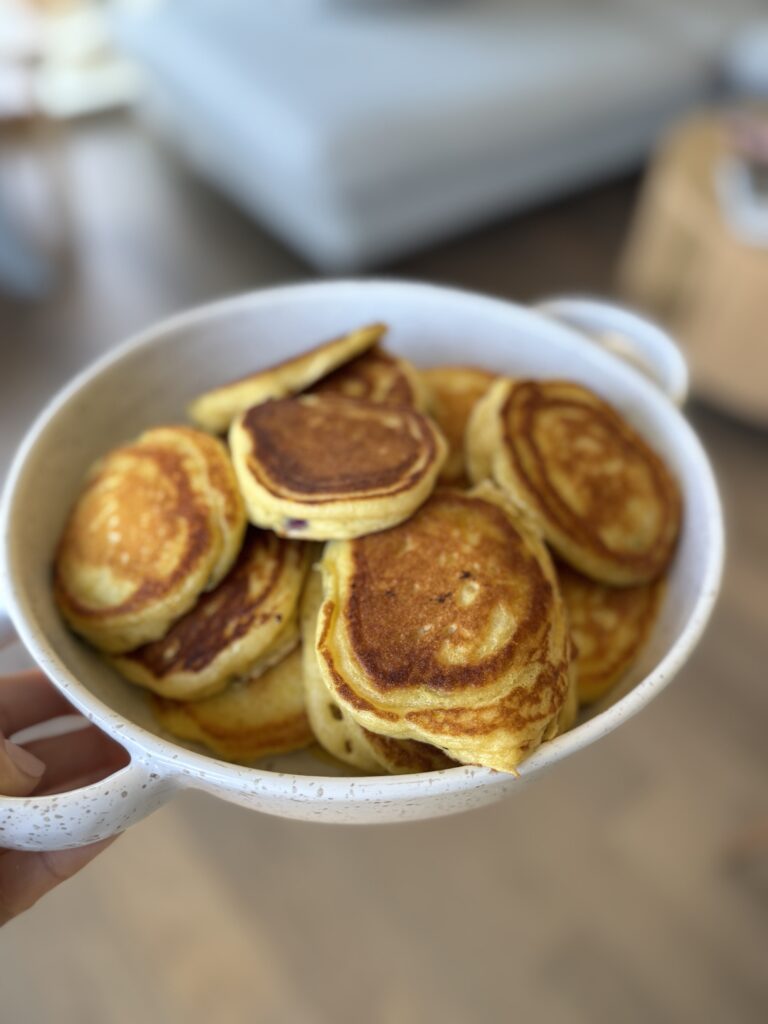 stack of greek yogurt pancakes in white bowl with sausage