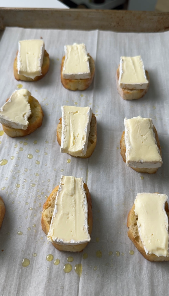 brie crostini with melted brie and strawberries drizzled with hot honey