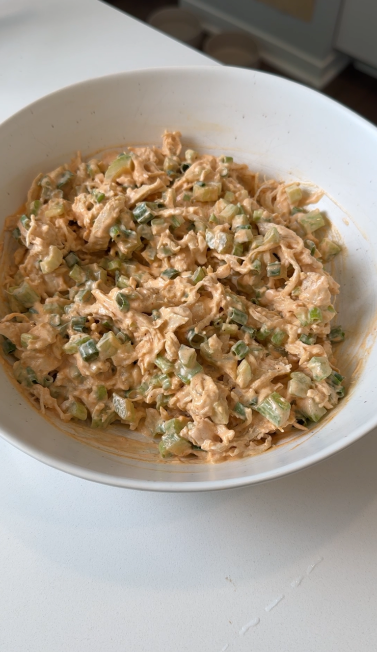 Close up of creamy healthy buffalo chicken salad with celery and green onion in a bowl