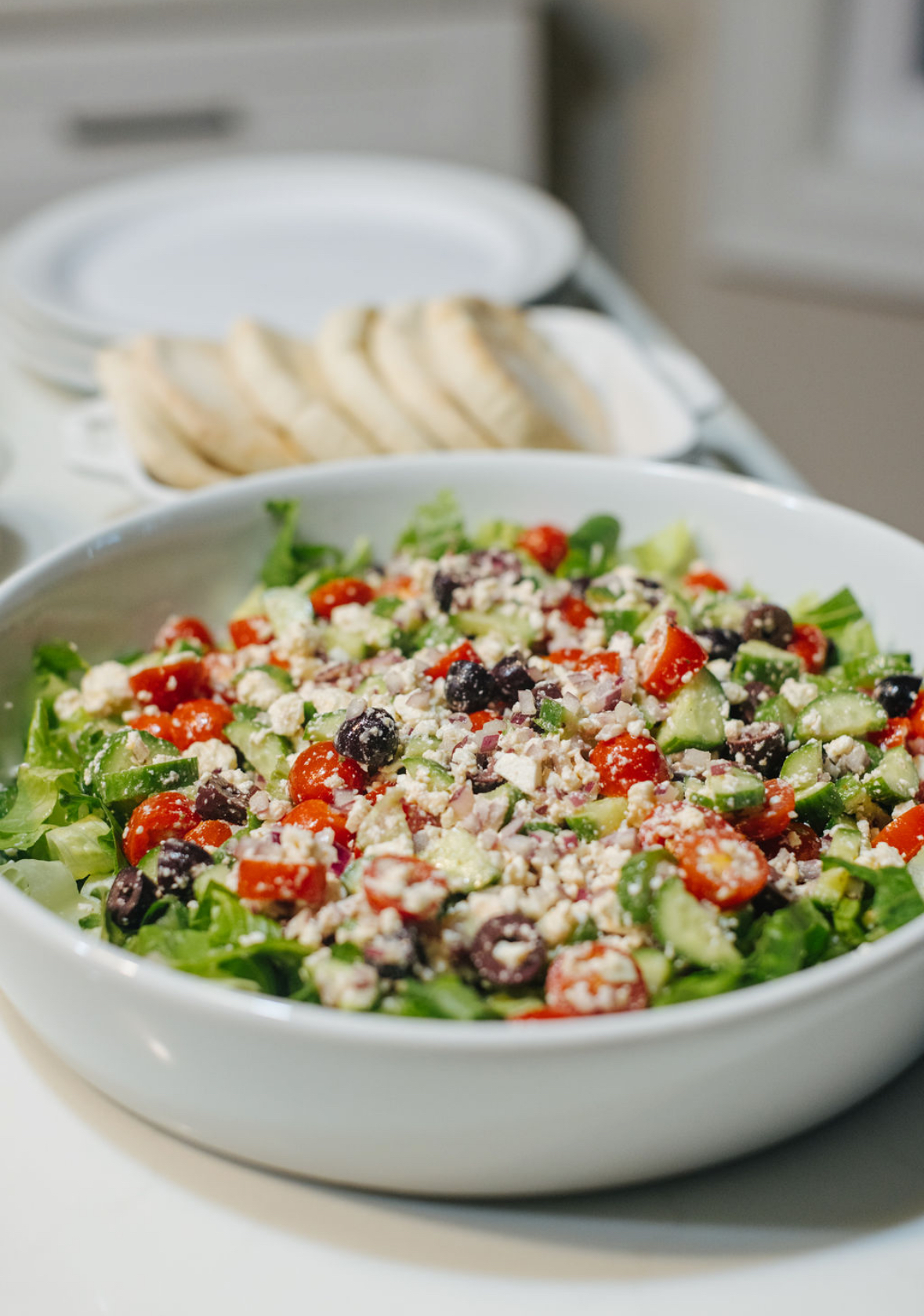 easy greek salad with homemade dressing in a white bowl
