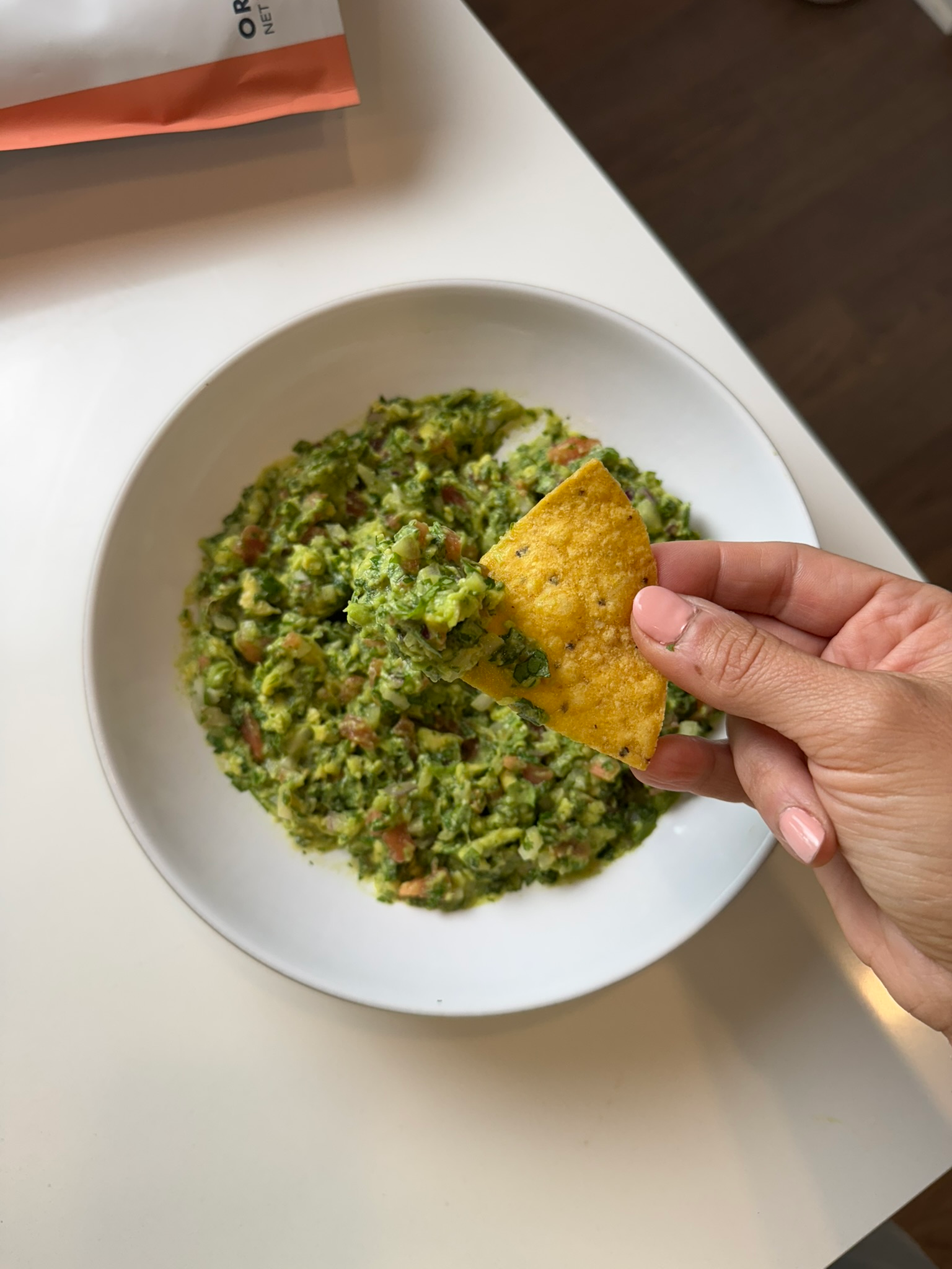 simple chunky guacamole in white bowl with tortilla chips