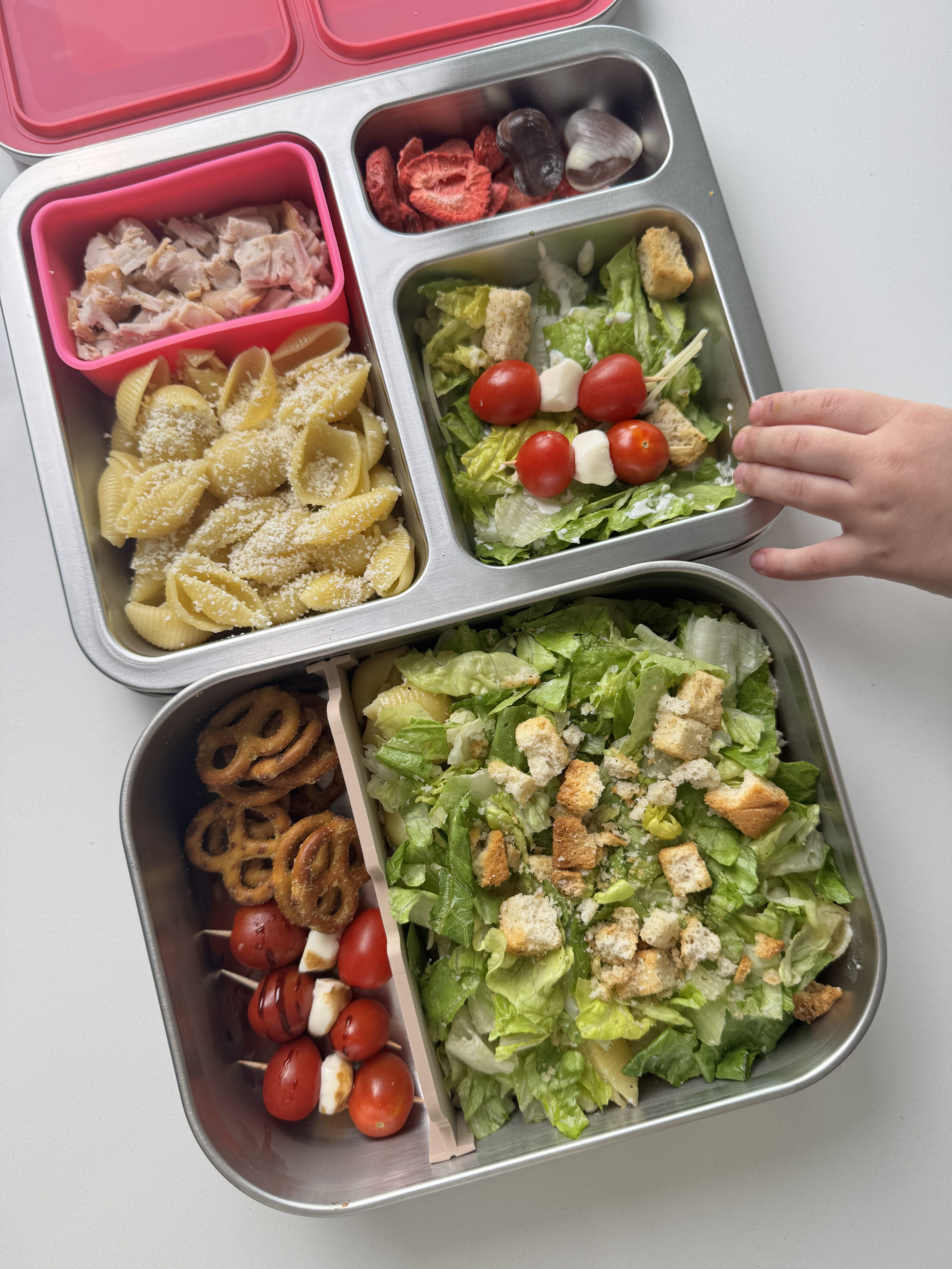 toddler friendly chicken caesar pasta salad bentgo box with buttered noodles, diced chicken, caesar salad, bocconcini skewers, freeze dried strawberries and chocolate