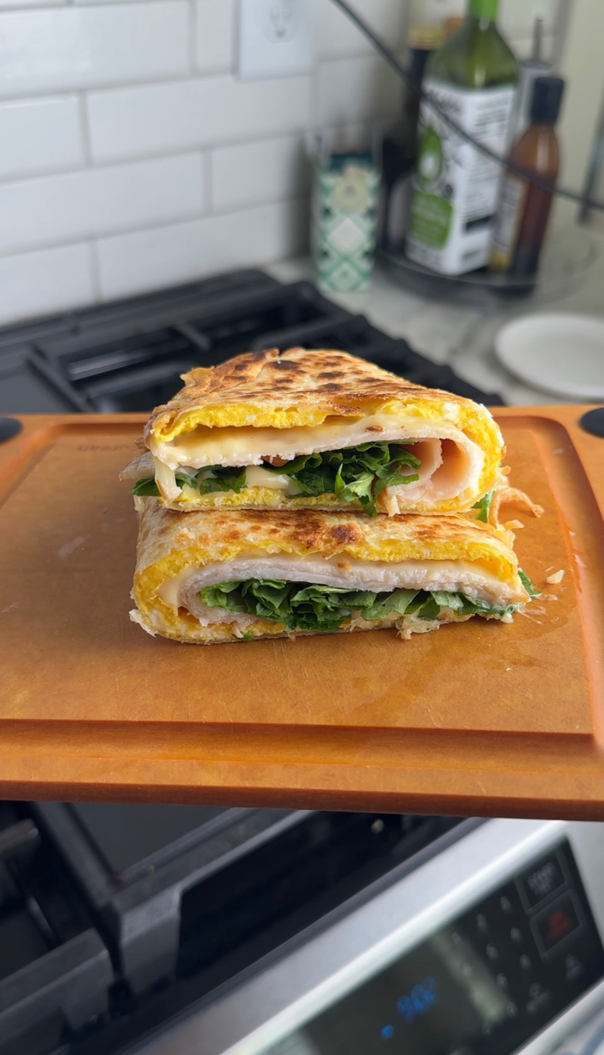 easy egg tortilla wrap with turkey, havarti, and arugula cut in half showing the layers