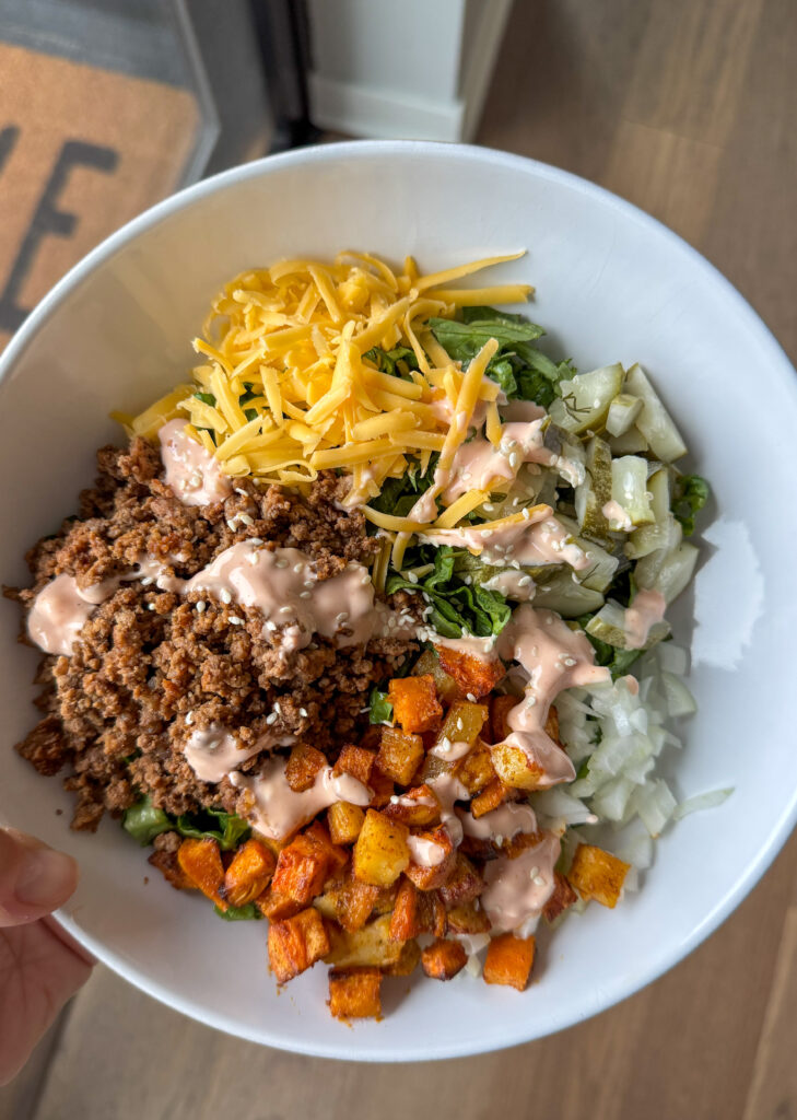 Close-up of an easy cheeseburger bowl with ground beef, cheese, and pickles