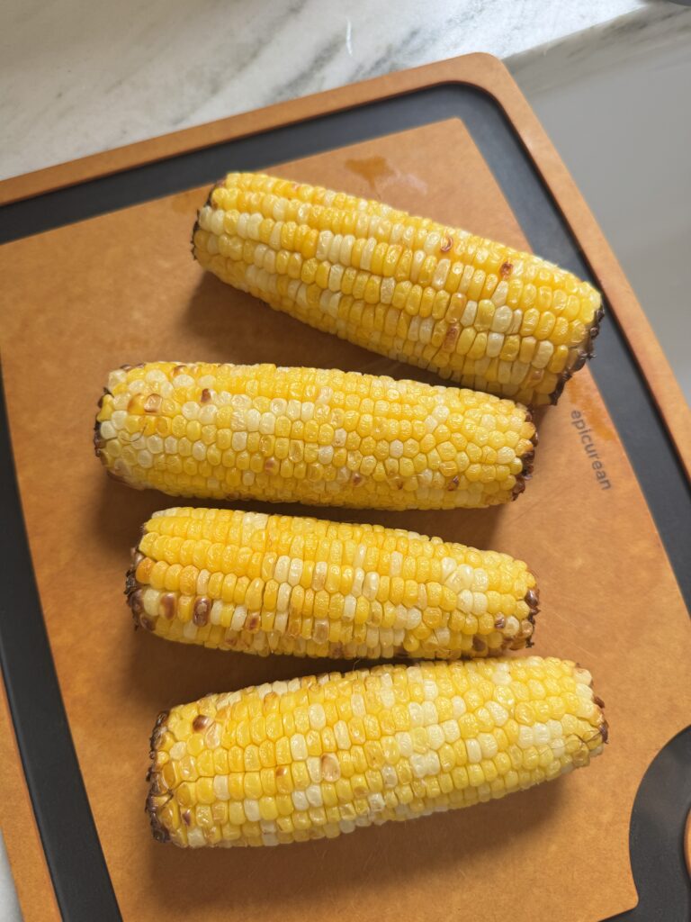Roasted corn, tomatoes, cucumber, and red onion for chopped corn salad