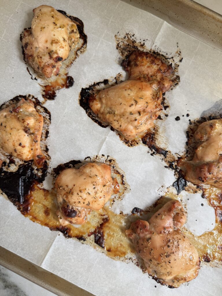 Baked balsamic chicken thighs with golden caramelized edges on a sheet pan