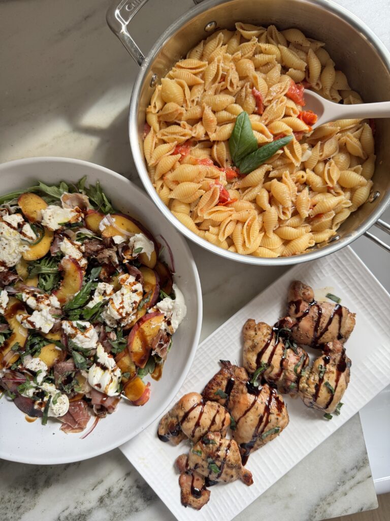 Balsamic chicken thighs served with a peach burrata salad and pink pasta for a summer dinner