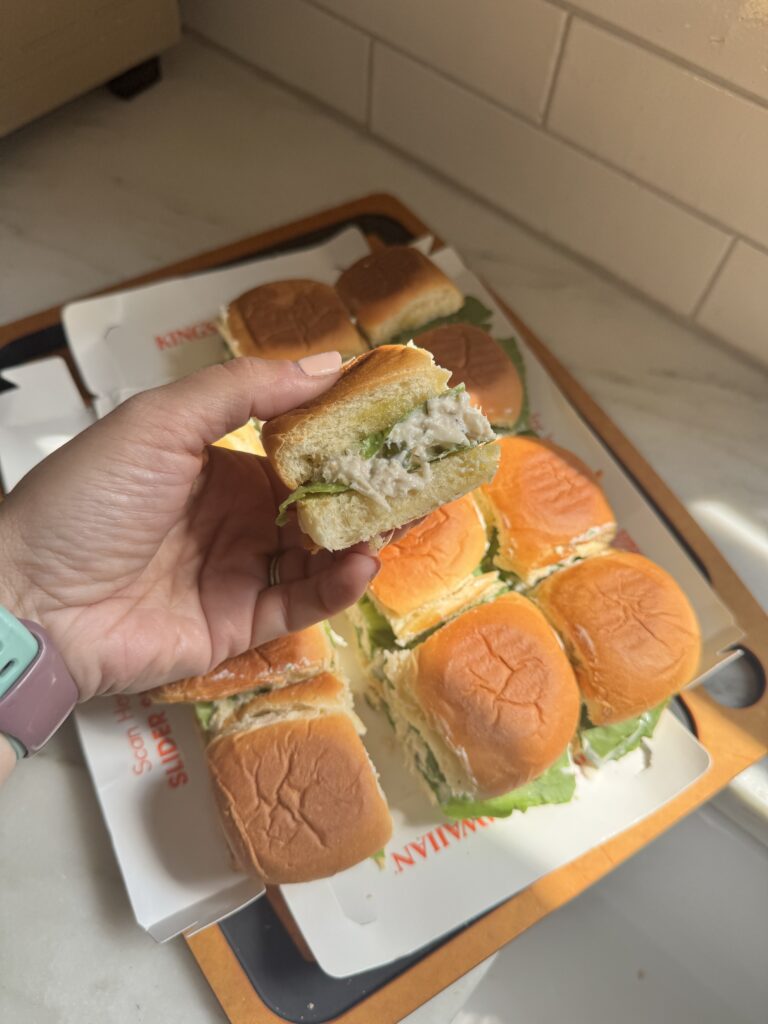 Dill pickle chicken sliders cut into squares on a Kings Hawaiian slider board