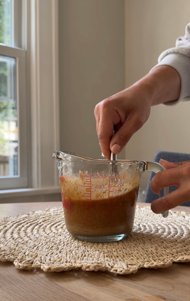 Whisking easy peanut sauce in a glass measuring cup