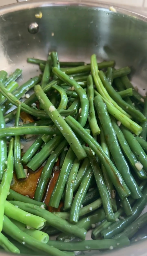 Sesame green beans sauteing in a skillet coated in a soy sesame glaze
