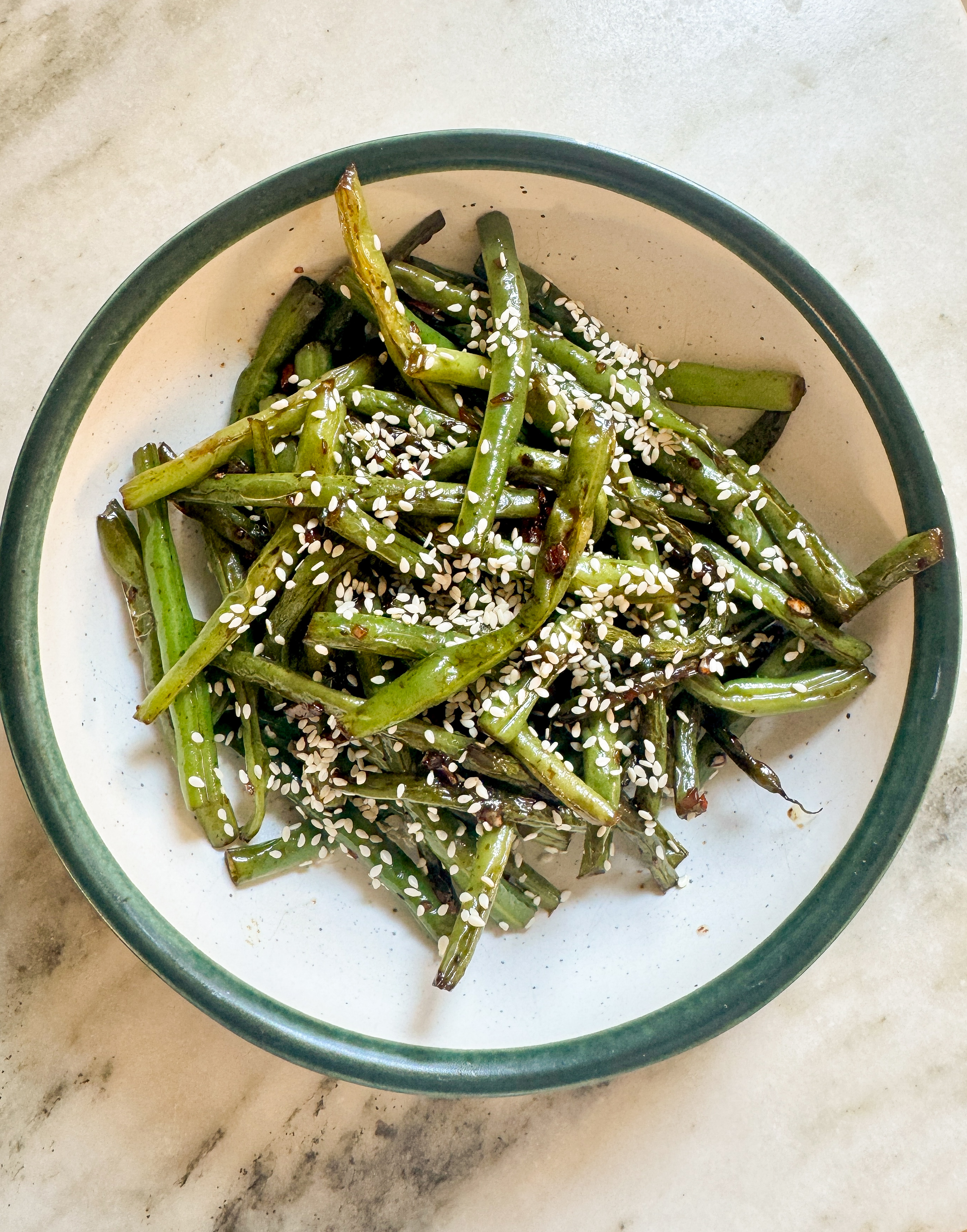 Easy sesame green beans in a bowl topped with toasted sesame seeds