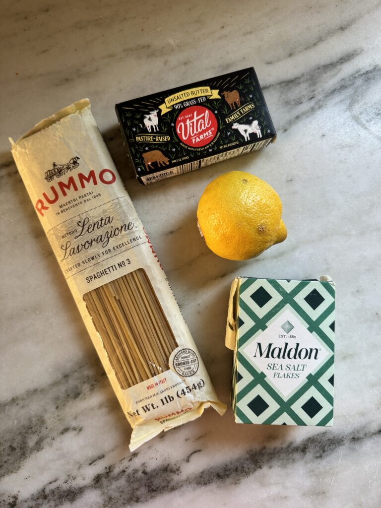 Pasta al limone ingredients: Rummo spaghetti, butter, a lemon, and Maldon sea salt on marble