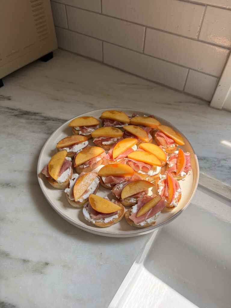 A plate of peach prosciutto crostini ready to serve
