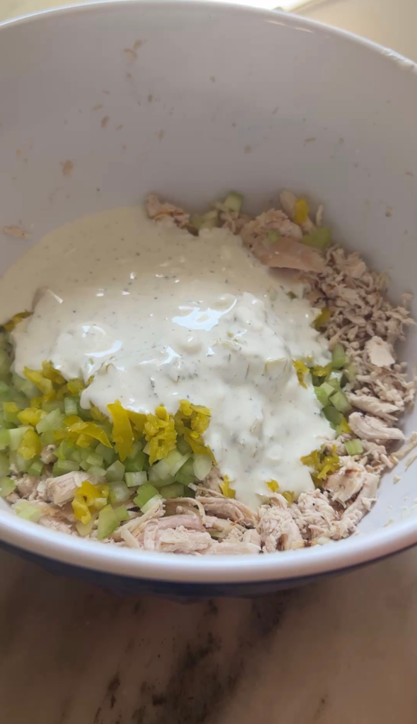 Shredded chicken, diced celery, and pepperoncini topped with creamy ranch dressing in a bowl