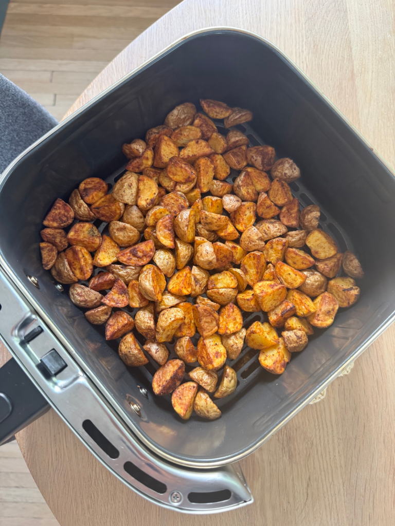 Crispy golden air fryer parmesan potatoes in the air fryer basket