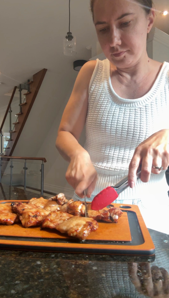 Dicing air fried teriyaki chicken thighs on a cutting board