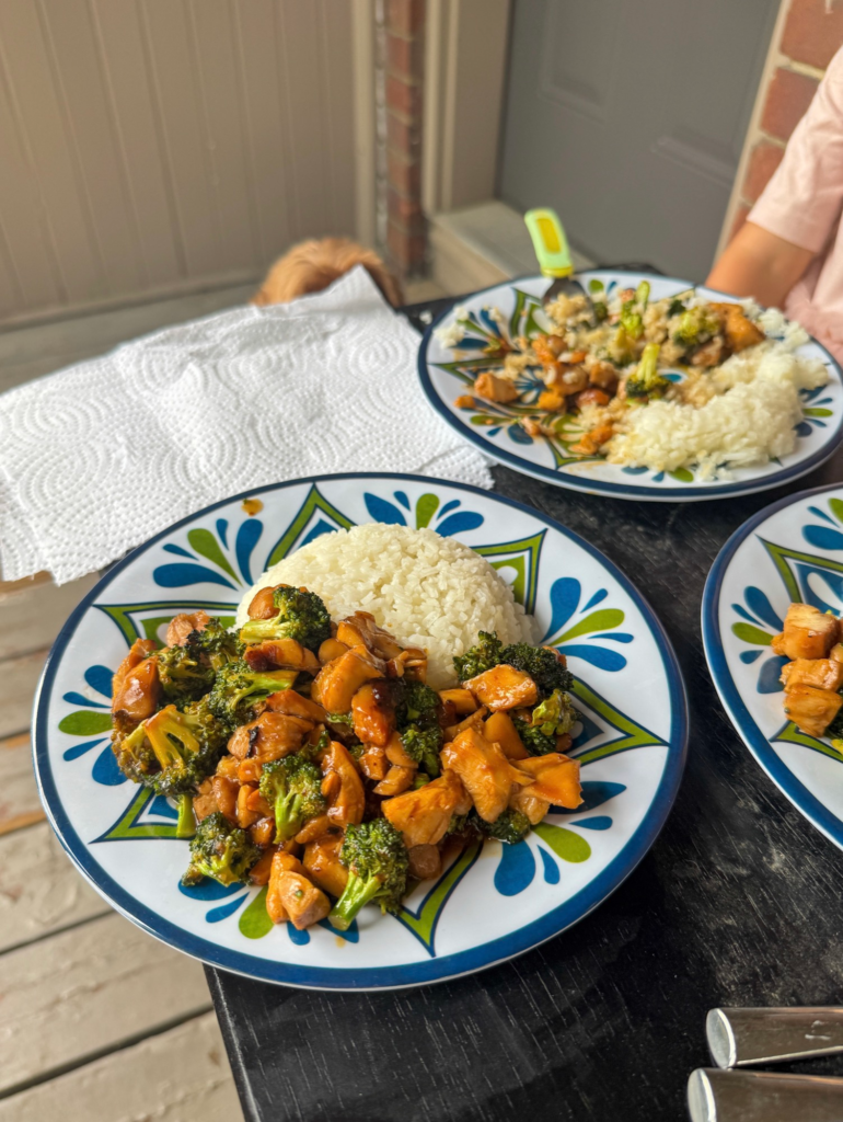 Plates of teriyaki chicken and broccoli over rice on a table