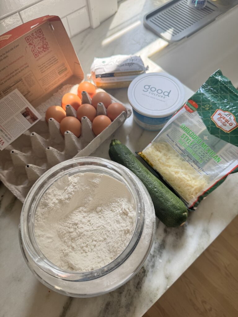 Eggs, flour, cottage cheese, shredded cheese, and zucchini for zucchini sausage biscuits