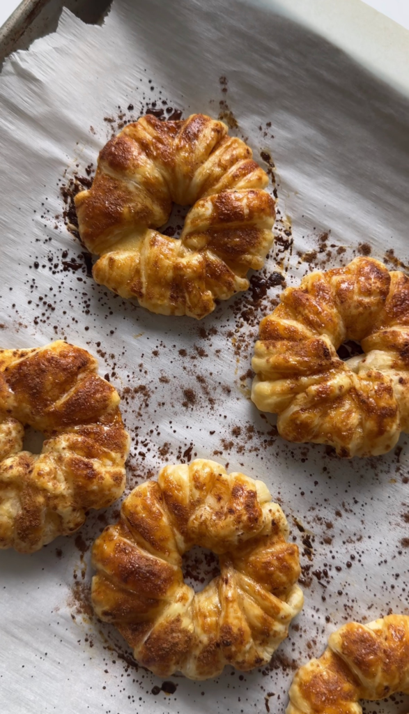 Baked apple cinnamon donuts on a parchment-lined tray