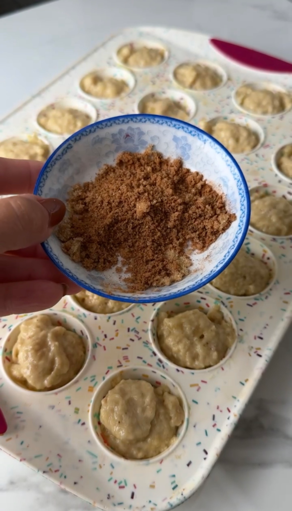Sprinkling cinnamon sugar over the muffin batter