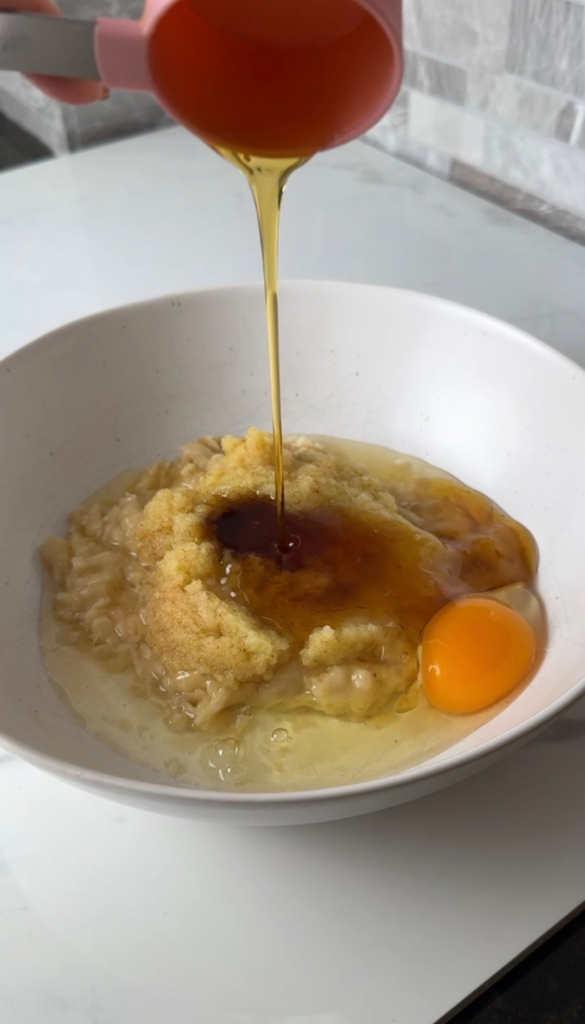 Adding maple syrup and egg to the muffin batter