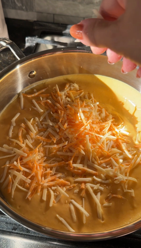 Shredded cheddar and Gruyere added to the butternut squash sauce