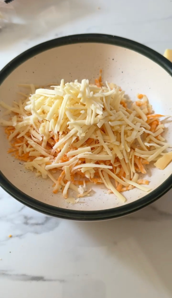 A bowl of freshly shredded cheddar and Gruyere cheese
