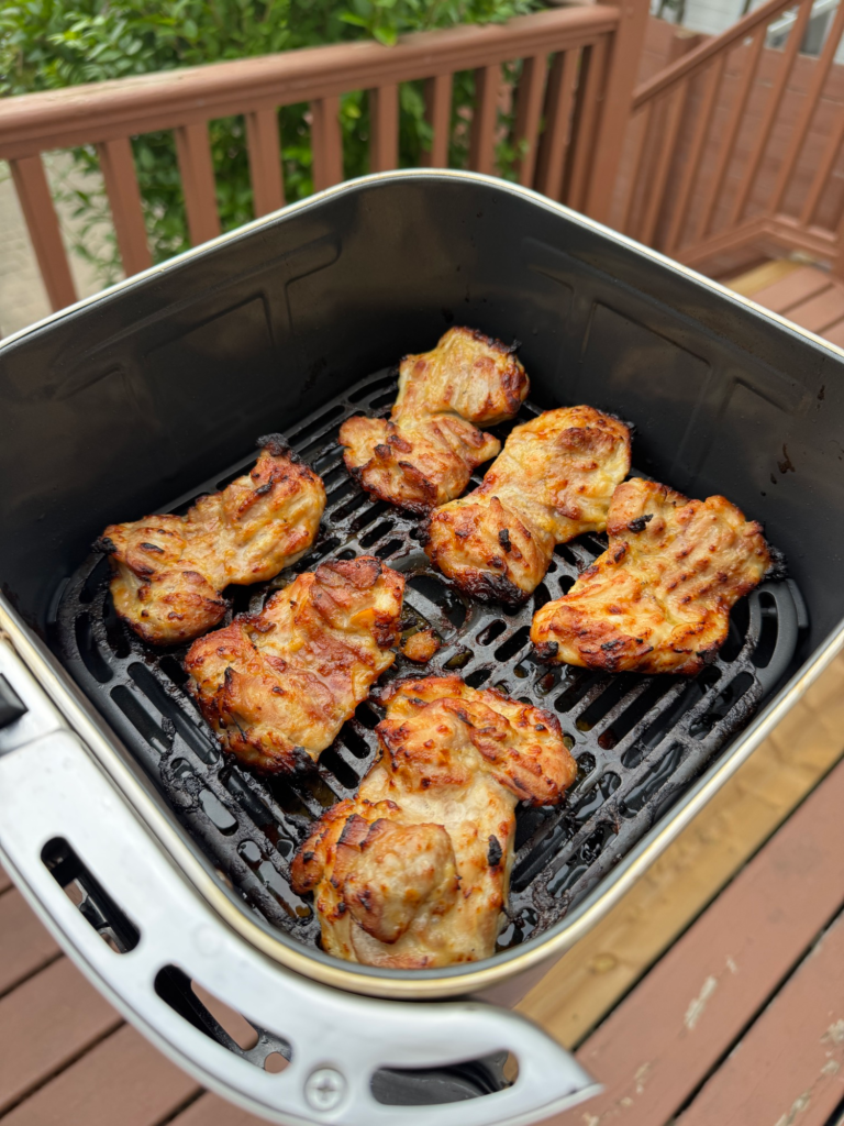 Maple Dijon chicken thighs in an air fryer basket