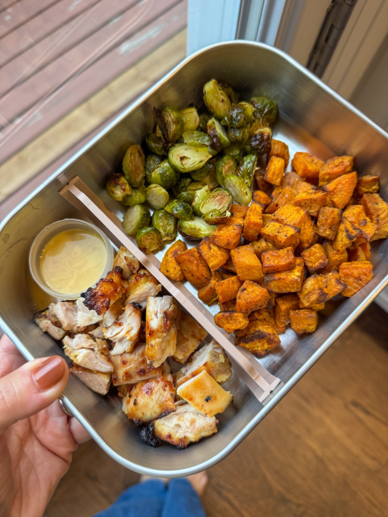 Fall harvest bowls made ahead in a meal prep container with chicken, sweet potato, and Brussels sprouts