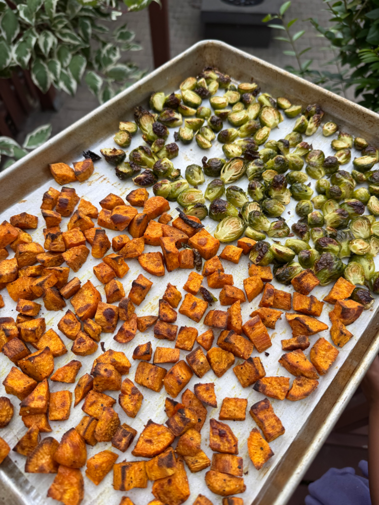 Roasted sweet potatoes and Brussels sprouts on a sheet pan