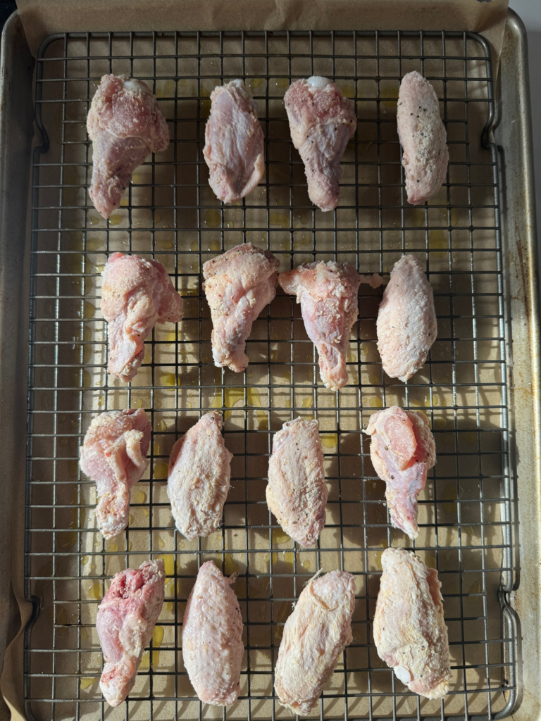 Seasoned chicken wings on a wire rack ready to bake