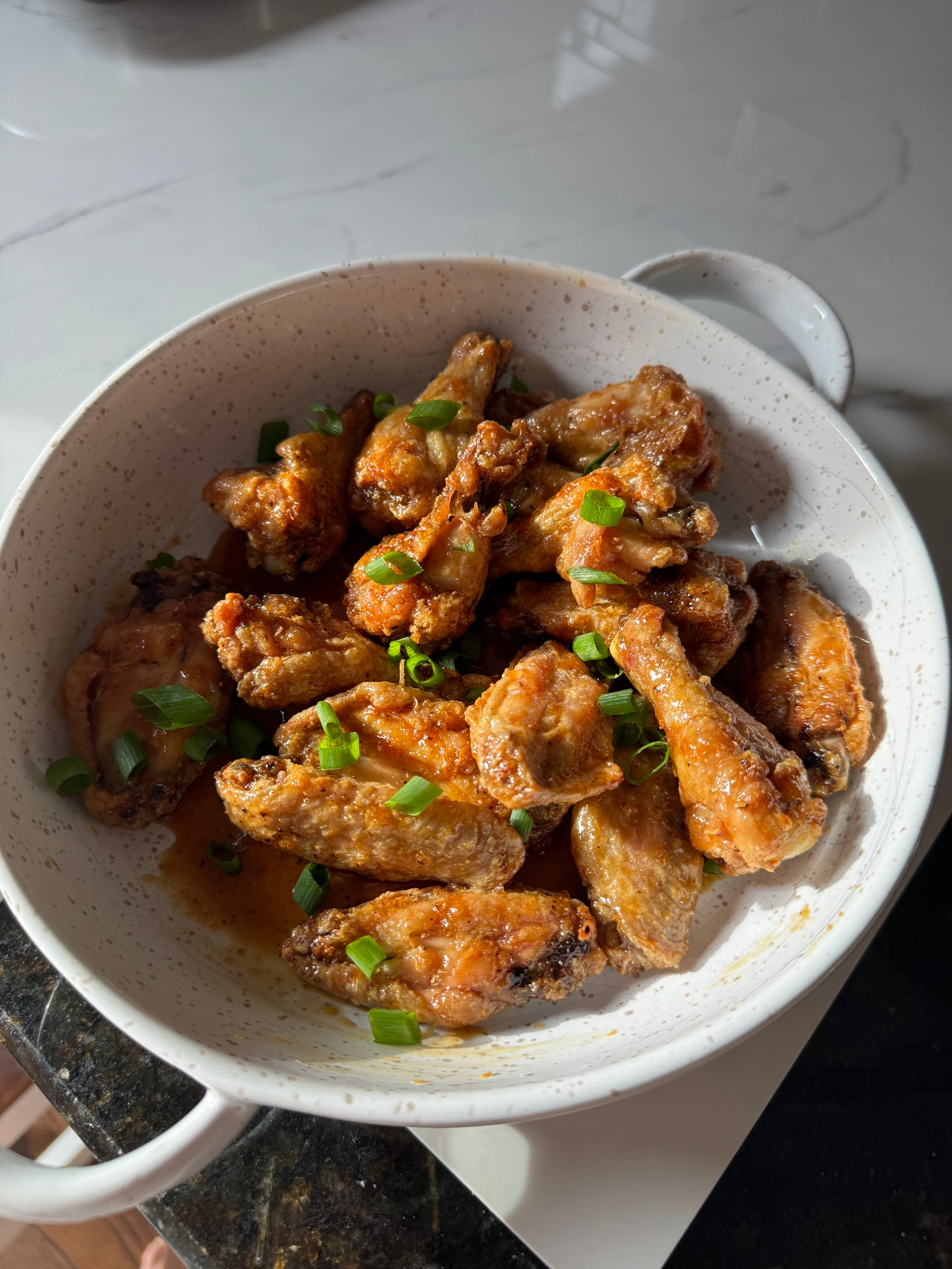 Oven baked crispy honey garlic wings garnished with scallions and sesame seeds