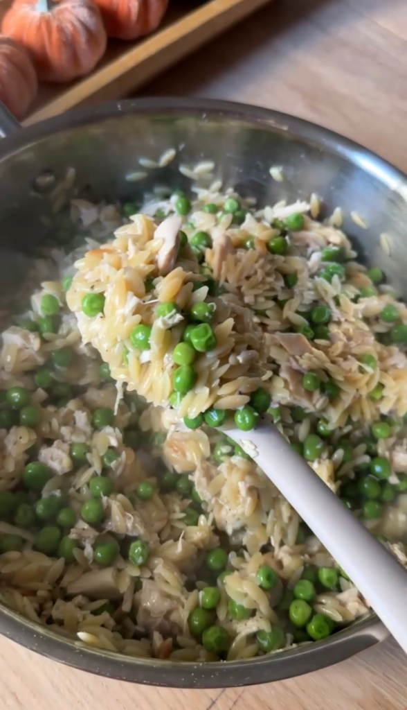 A spoonful of creamy peas and parmesan orzo with chicken