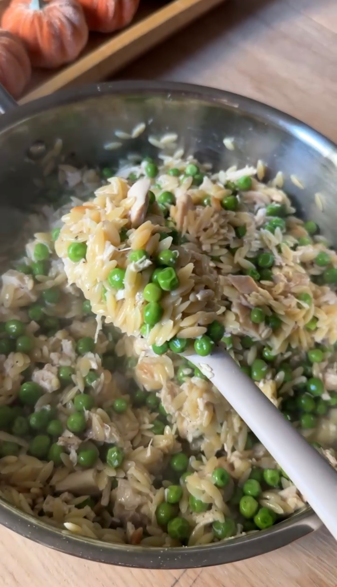 A spoonful of creamy peas and parmesan orzo with chicken