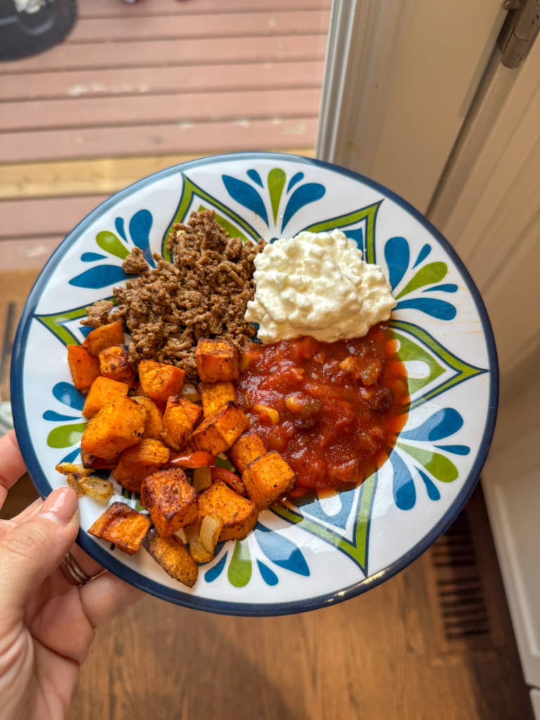 A sweet potato taco bowl with taco beef, a scoop of cottage cheese, and salsa