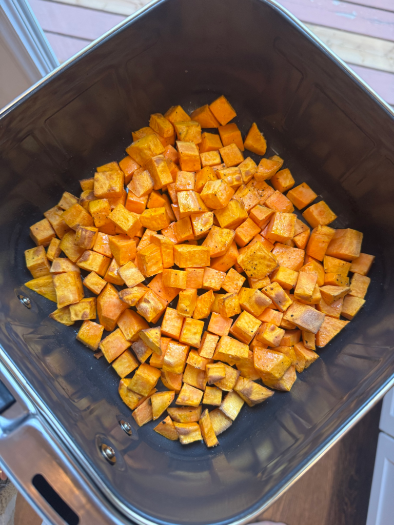 Diced sweet potatoes in an air fryer basket