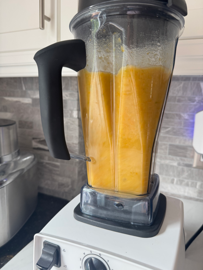 Creamy blended vegetable soup being pureed smooth in a blender