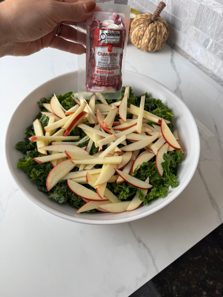 Apple matchsticks and cranberry goat cheese added to massaged kale