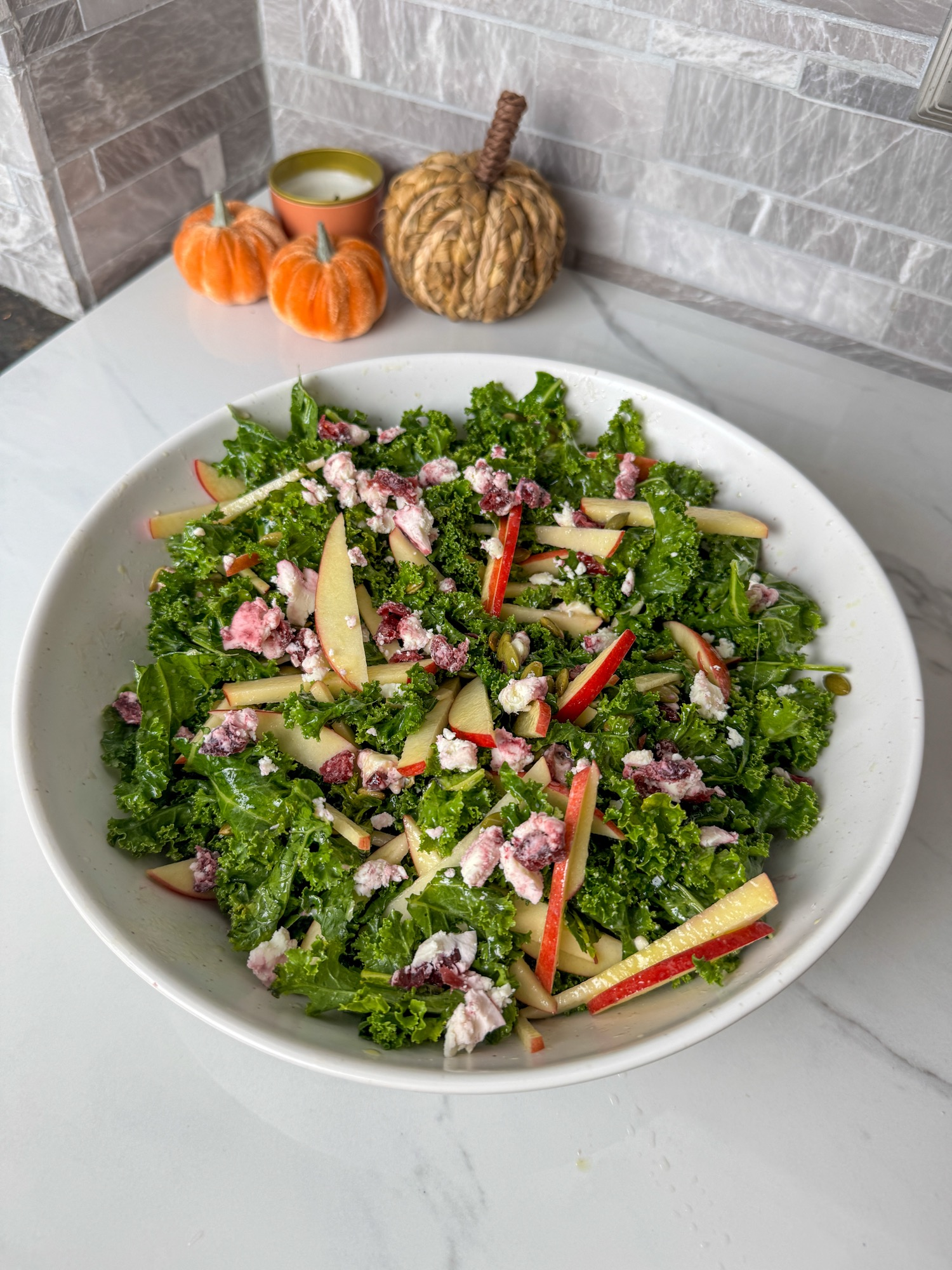 A served bowl of apple goat cheese kale salad