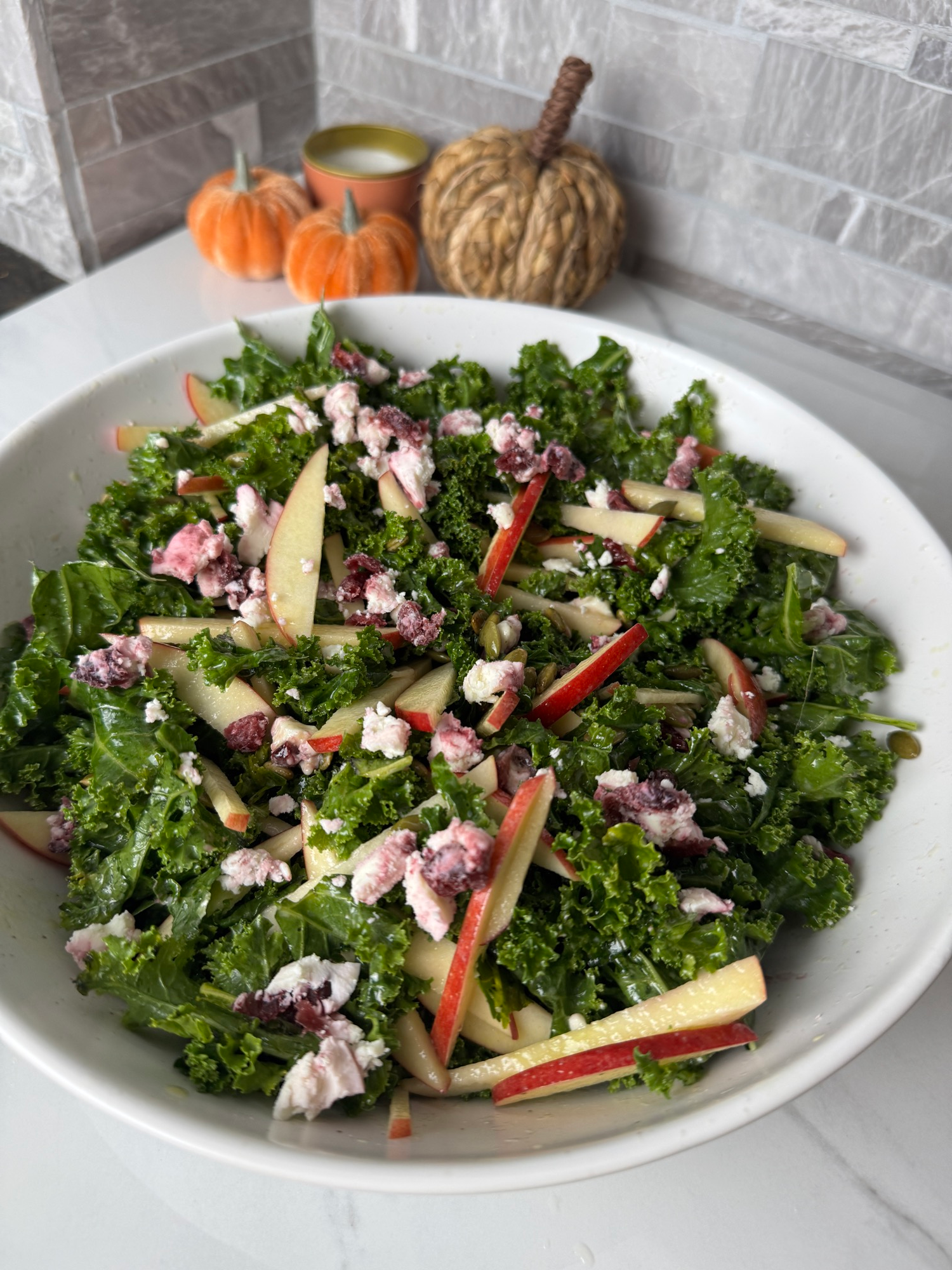 Apple goat cheese kale salad in a white bowl