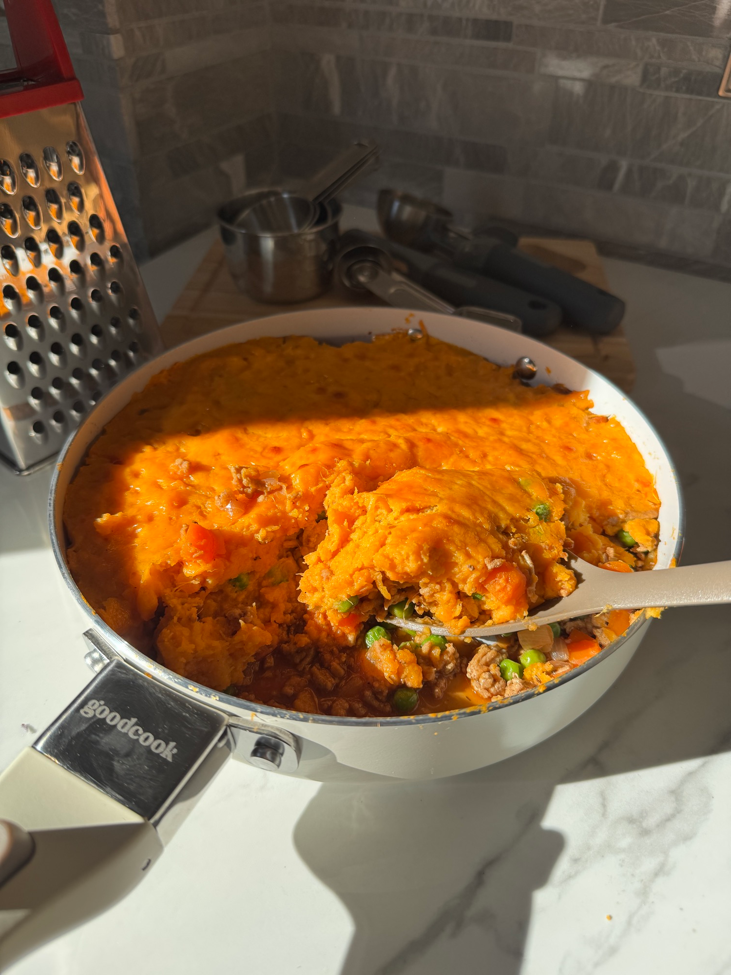 Baked sweet potato shepherd's pie with golden cheddar topping in a skillet