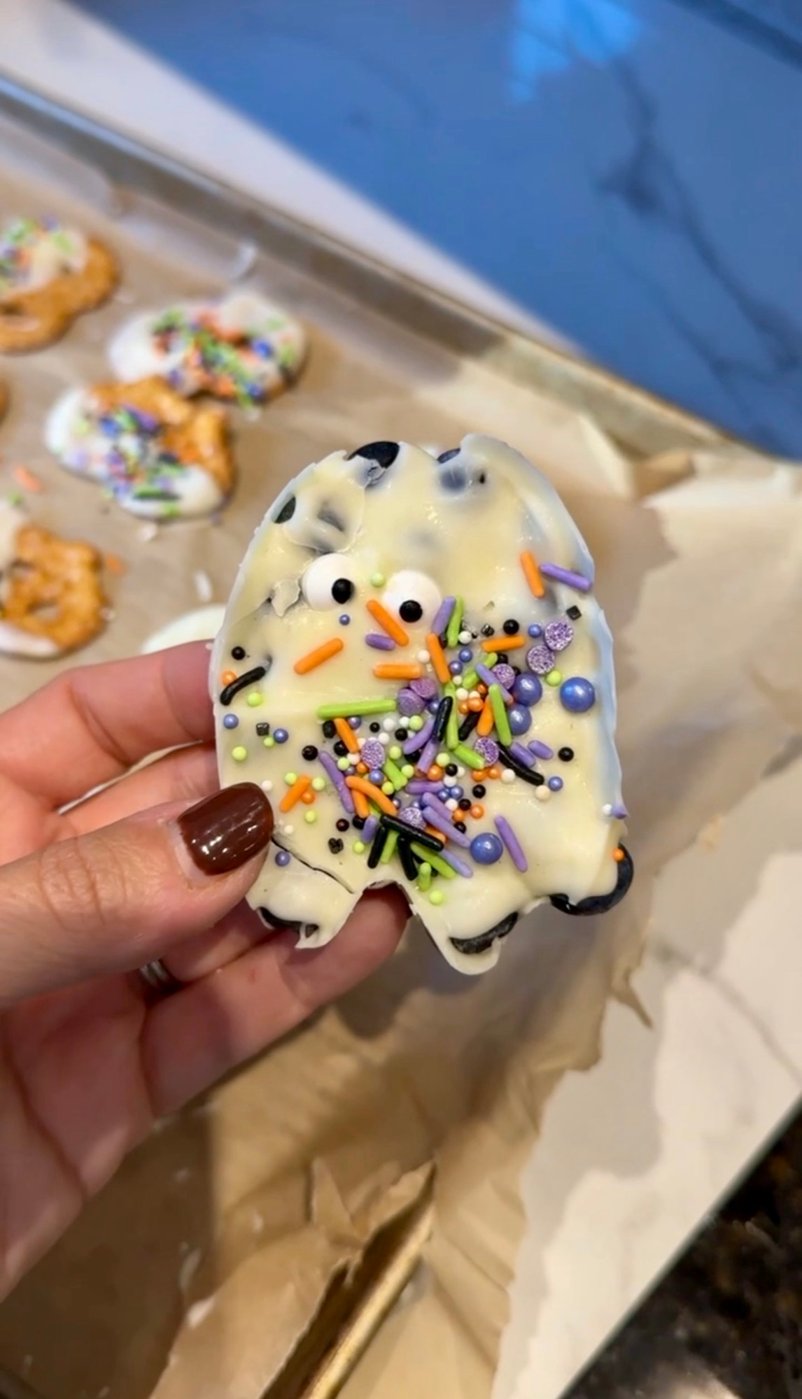 A ghost-shaped blueberry and white chocolate treat with candy eyes and sprinkles