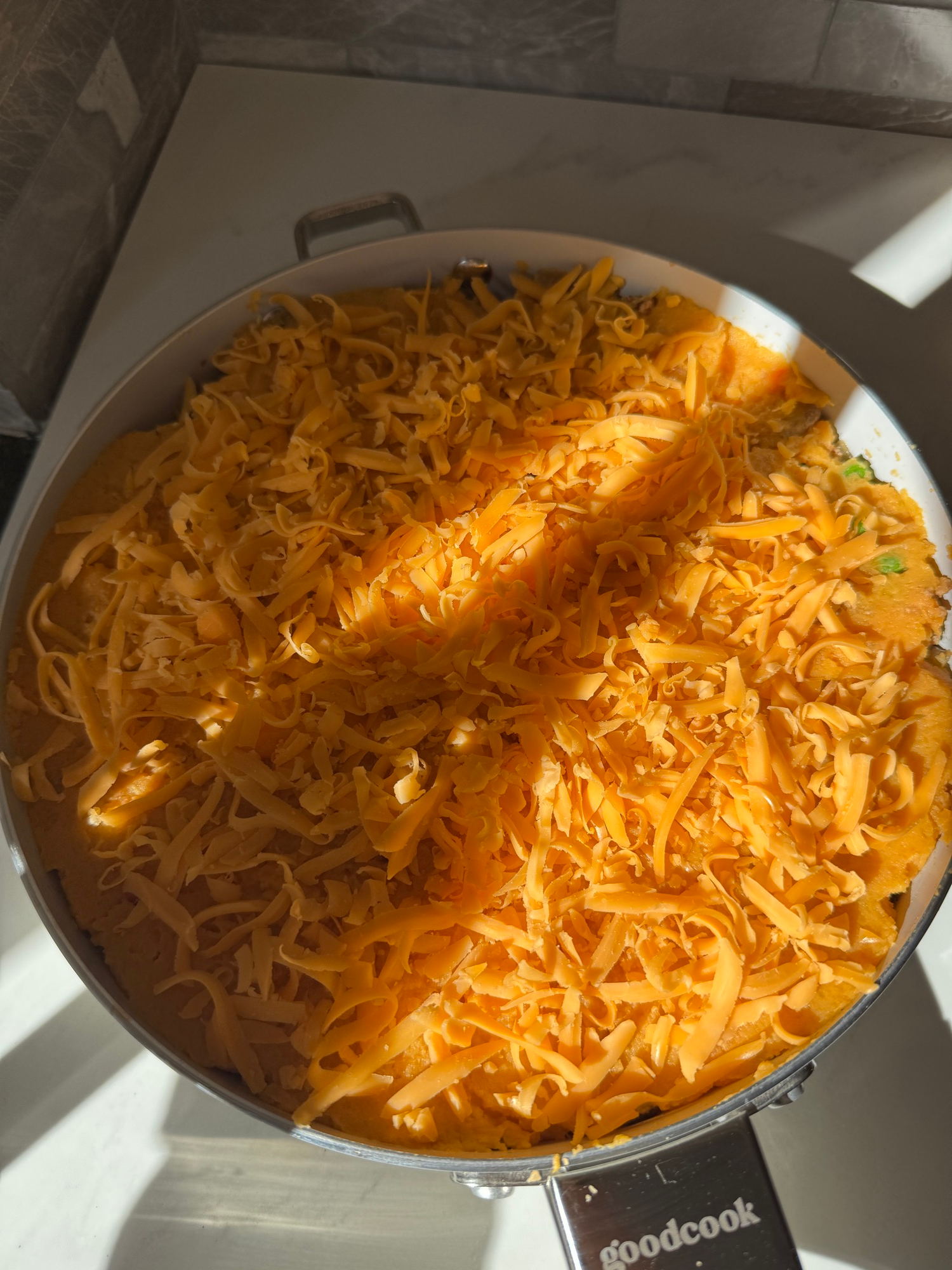 Shredded cheddar sprinkled over mashed sweet potato before baking