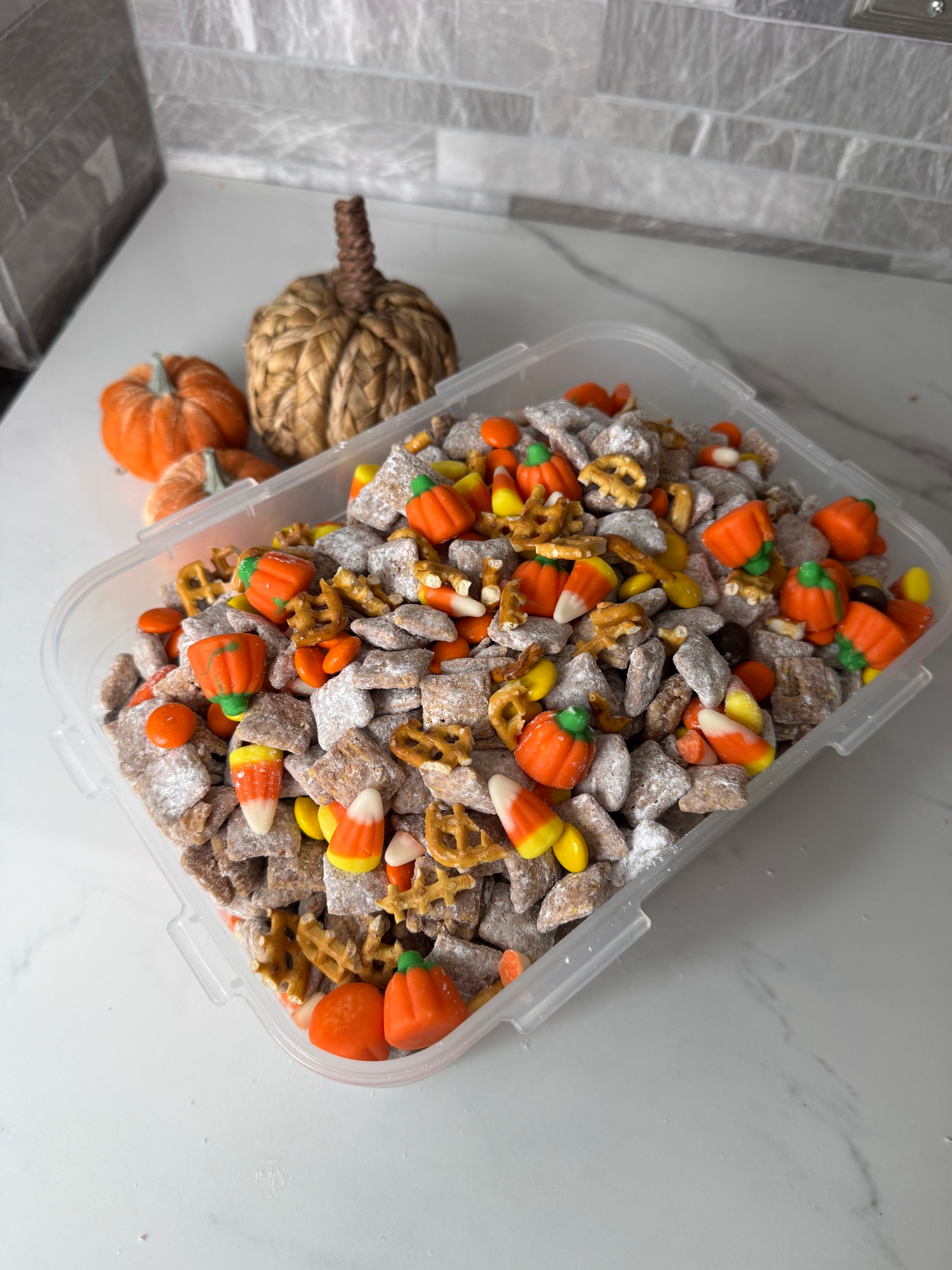 Halloween puppy chow stored in a container with festive candy