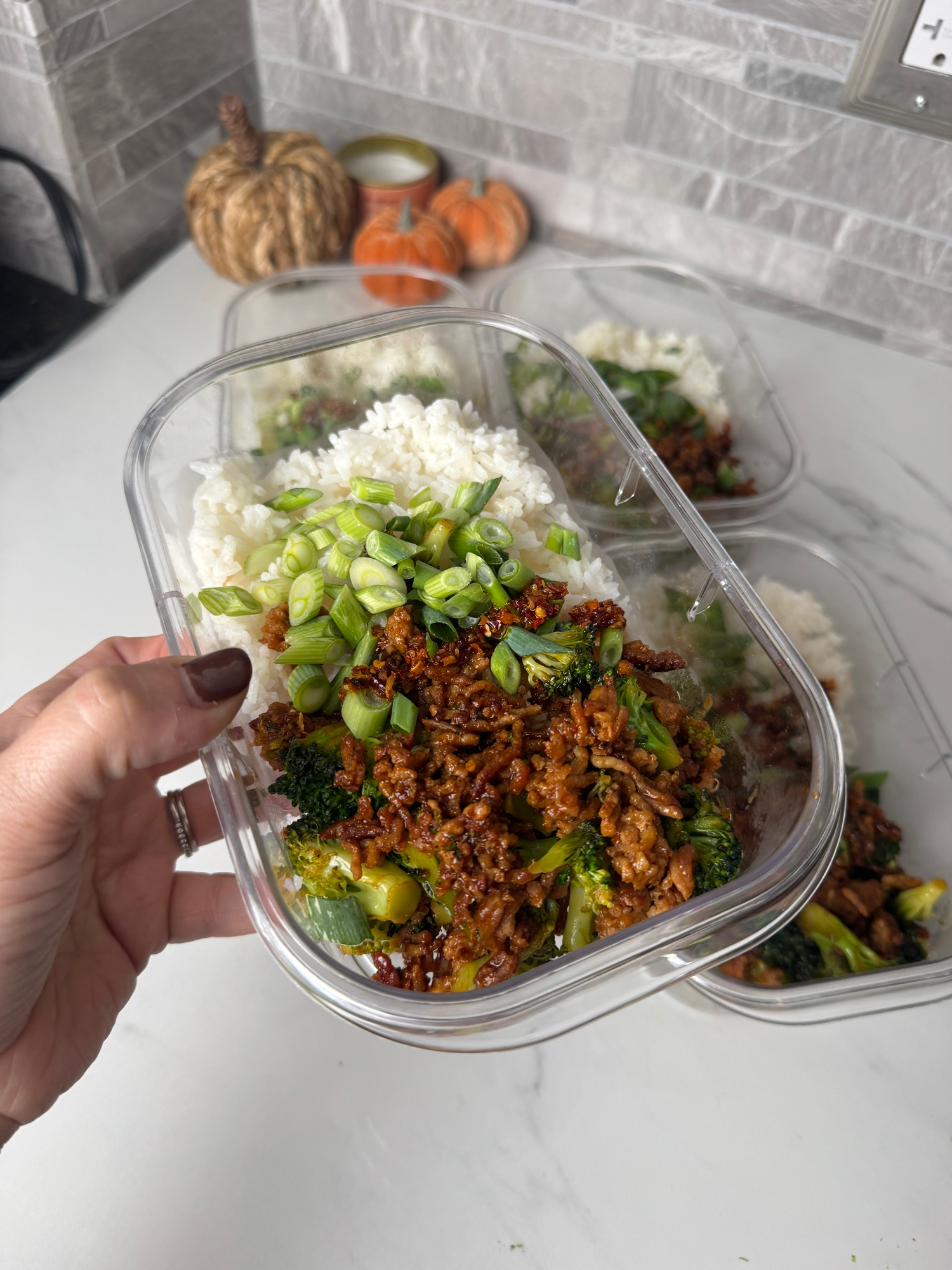 A meal prep container of Korean ground pork with broccoli, rice, and chili oil