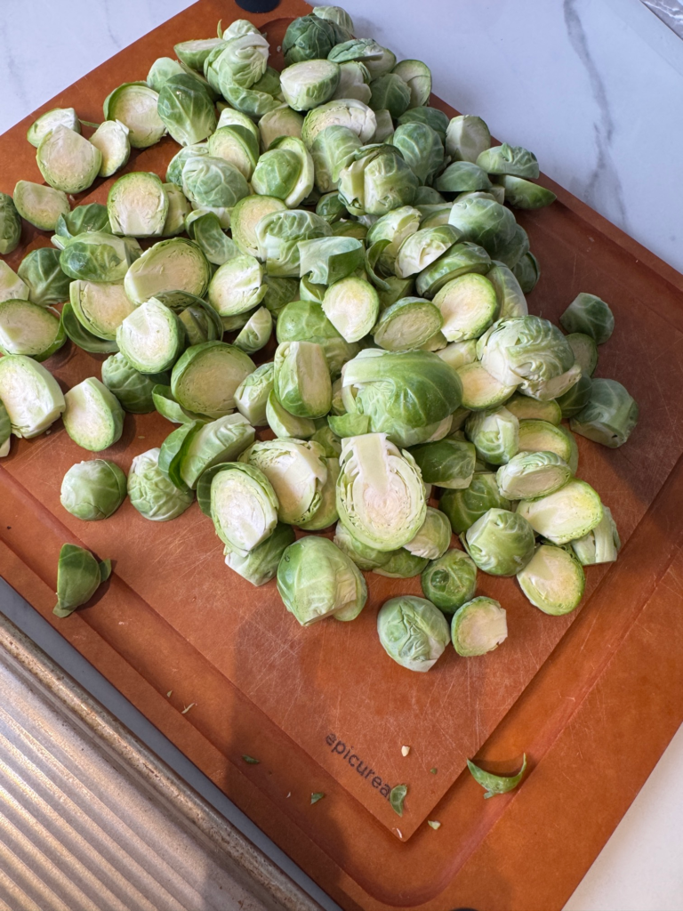 Halved maple bacon brussels sprouts on a cutting board ready for roasting