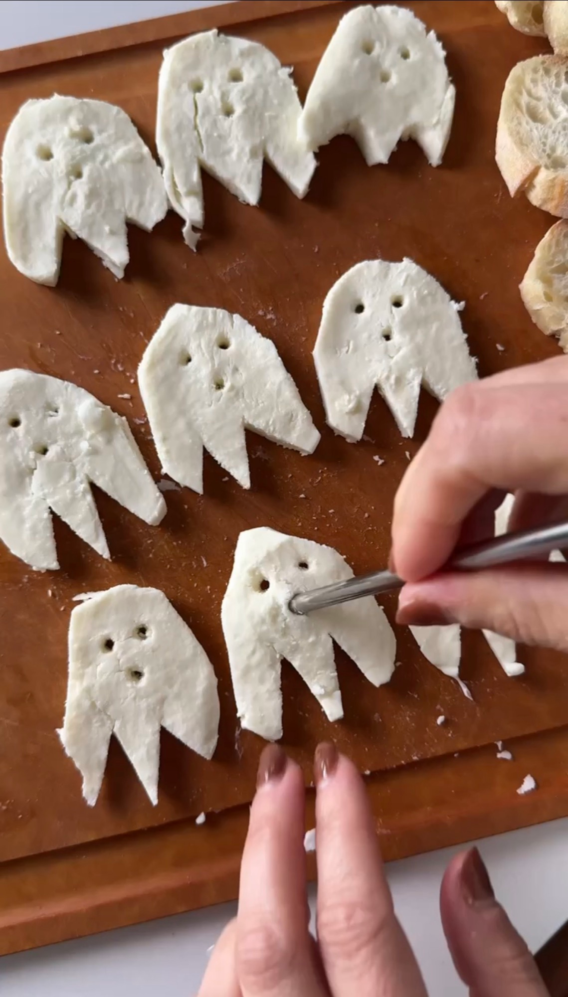 Cutting ghost shapes from fresh mozzarella slices