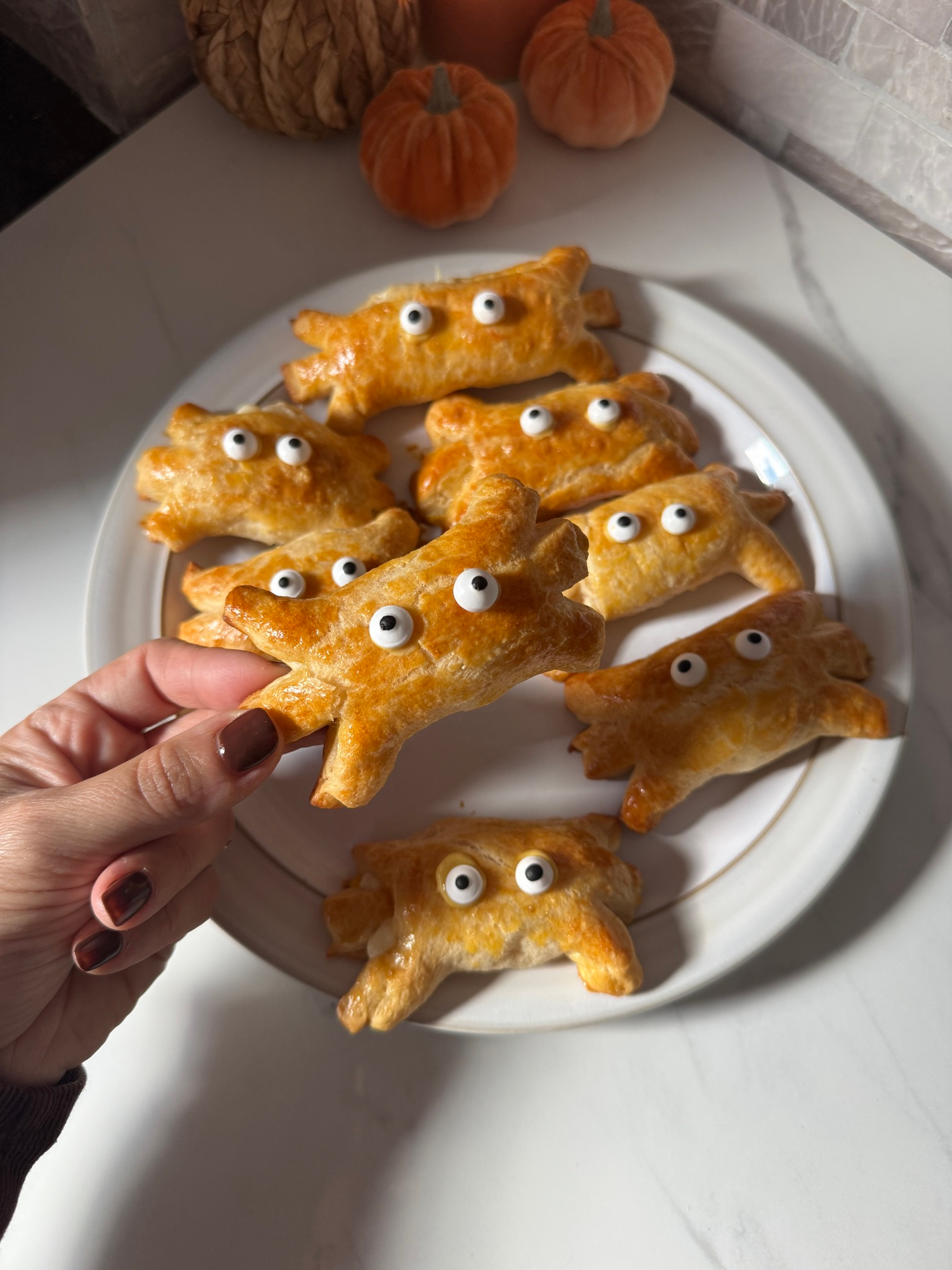 Holding a crescent roll mozzarella spider with candy eyes
