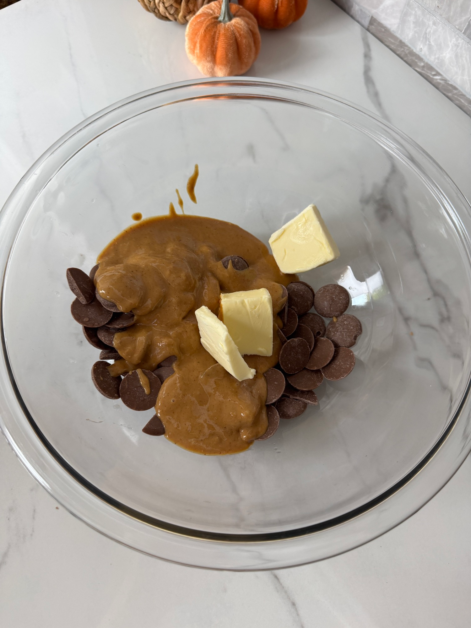 Chocolate chips, peanut butter, and butter in a glass bowl