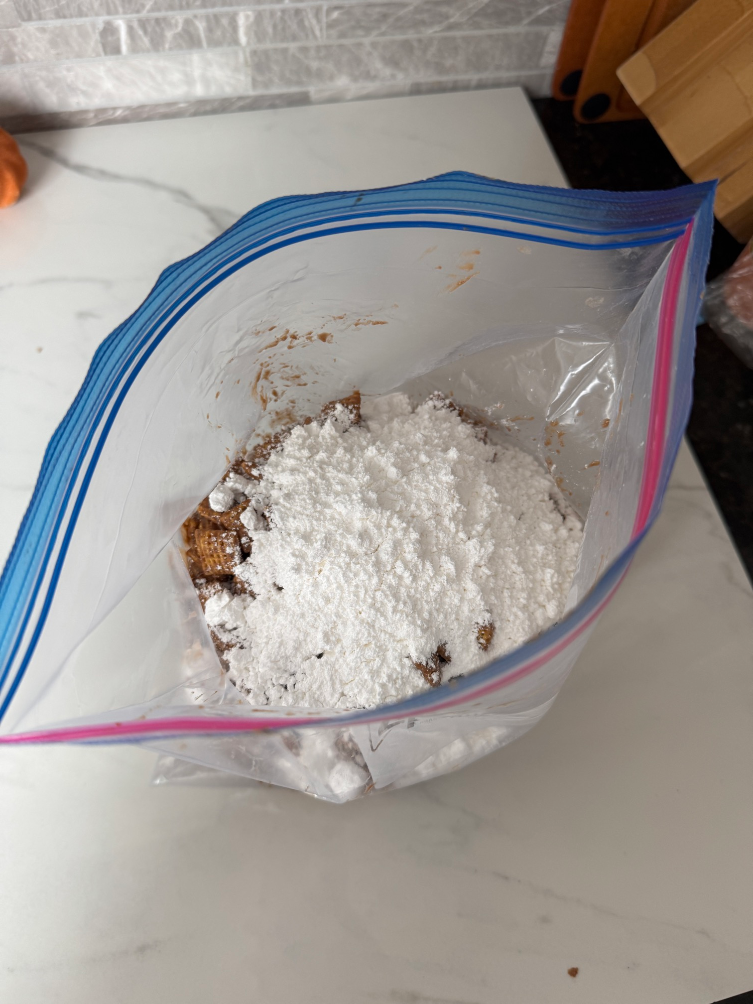 Chex coated puppy chow tossed with powdered sugar in a ziplock bag